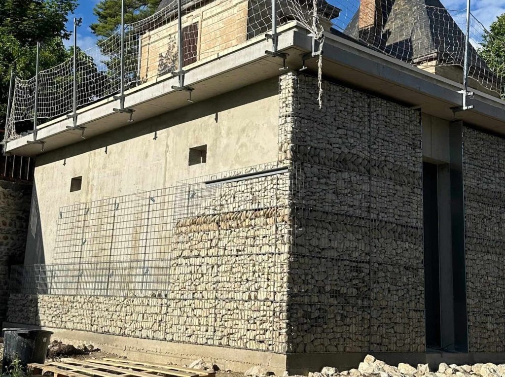 Habillage architectural en gabions électrosoudés sur un bâtiment en cours de réalisation